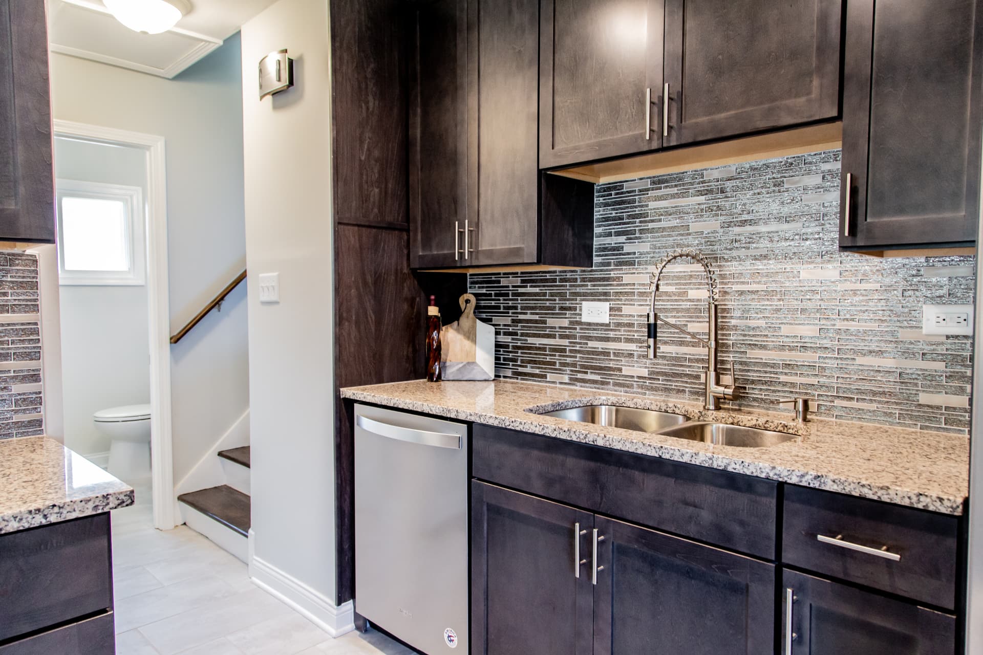 Dark Shaker Kitchen & Granite Counters after photo: Sink wall with dishwasher and view toward the stairwell