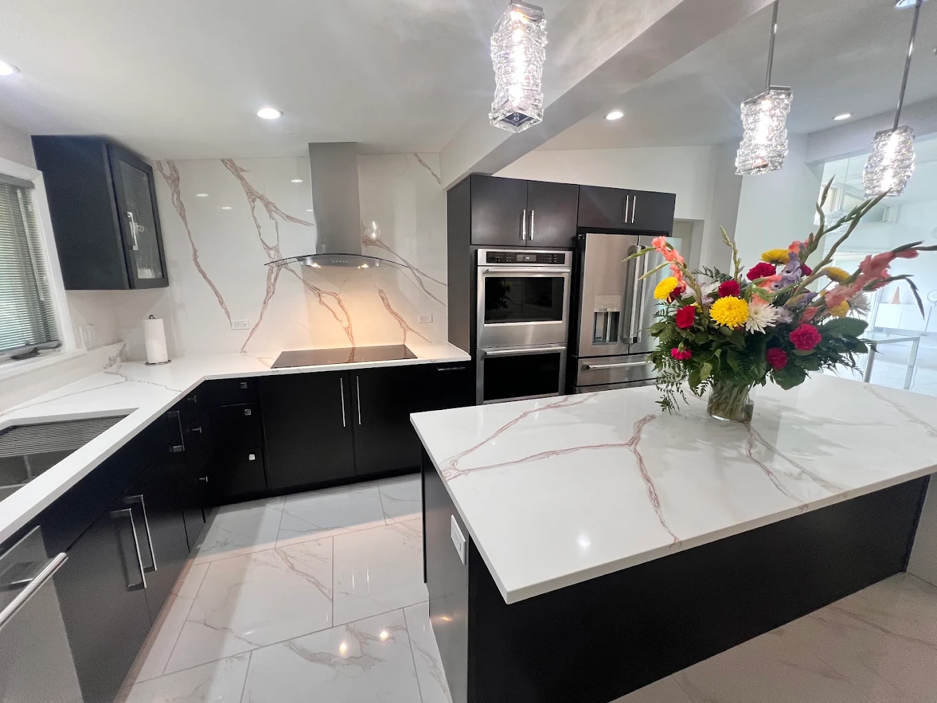 Dark Cabinetry & Marble-Look Kitchen after photo: Kitchen with dark cabinetry and marble-look backsplash