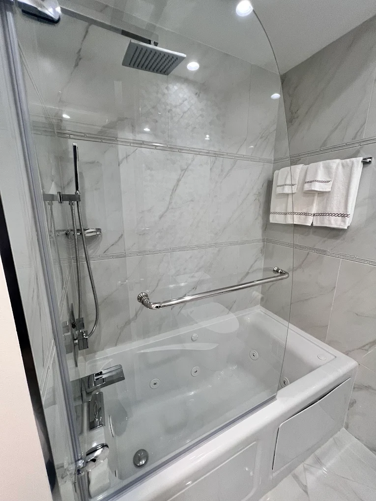 Polished Chrome Jetted Tub after photo: Jetted tub-shower with glass panel and marble-look tile
