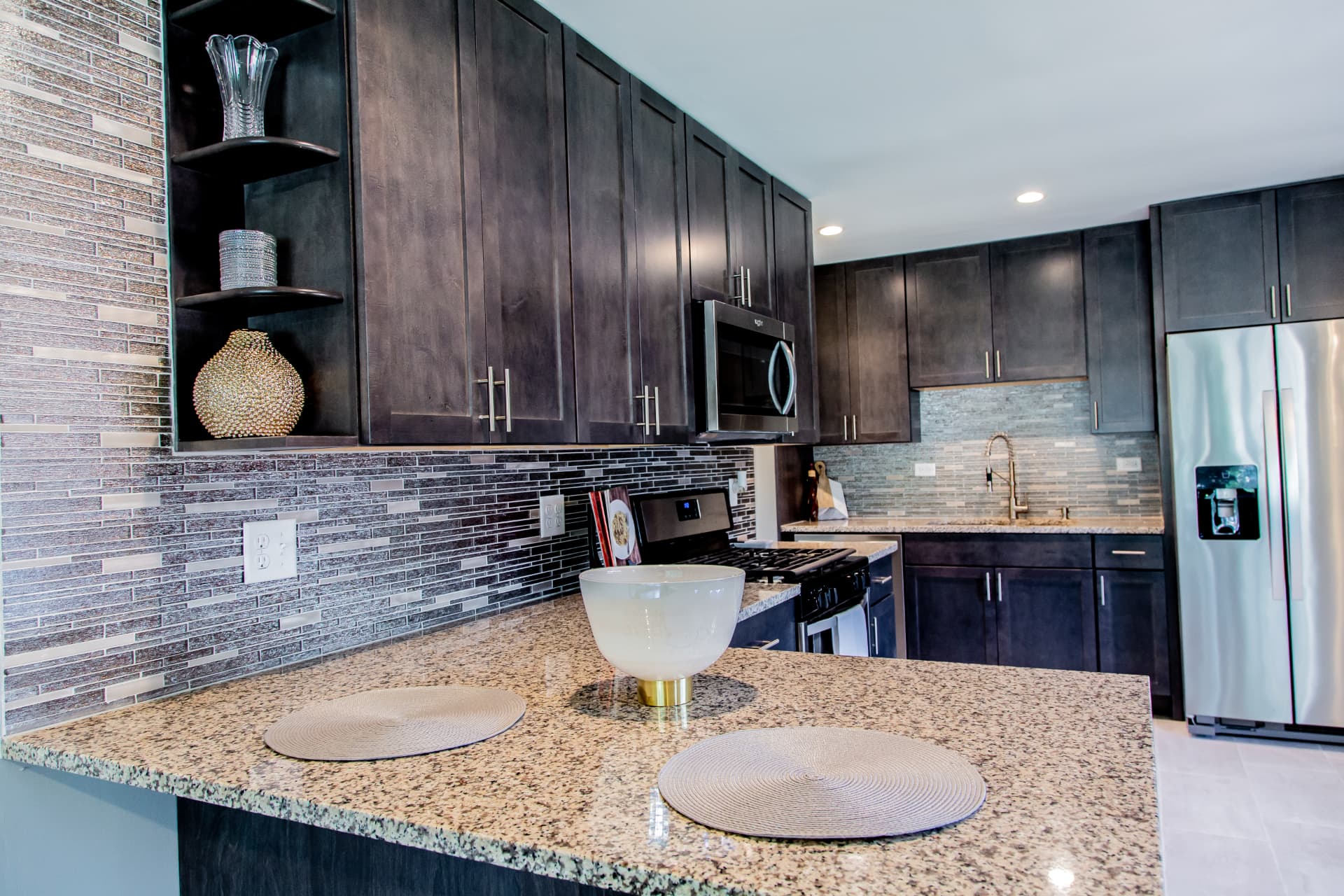 Dark Shaker Kitchen & Granite Counters after photo: Peninsula with corner display shelves and mosaic backsplash
