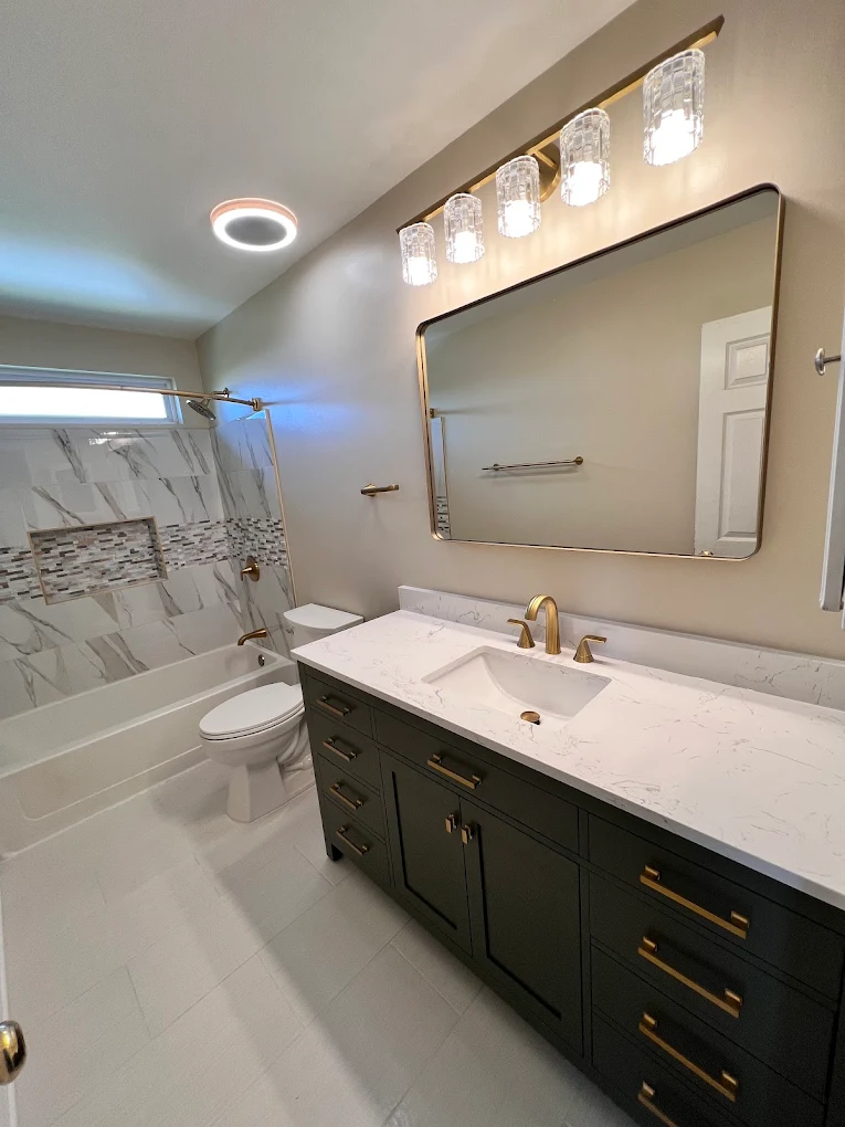 Dark Green Vanity Hall Bath after photo: Hall bath with dark green vanity and brushed gold fixtures