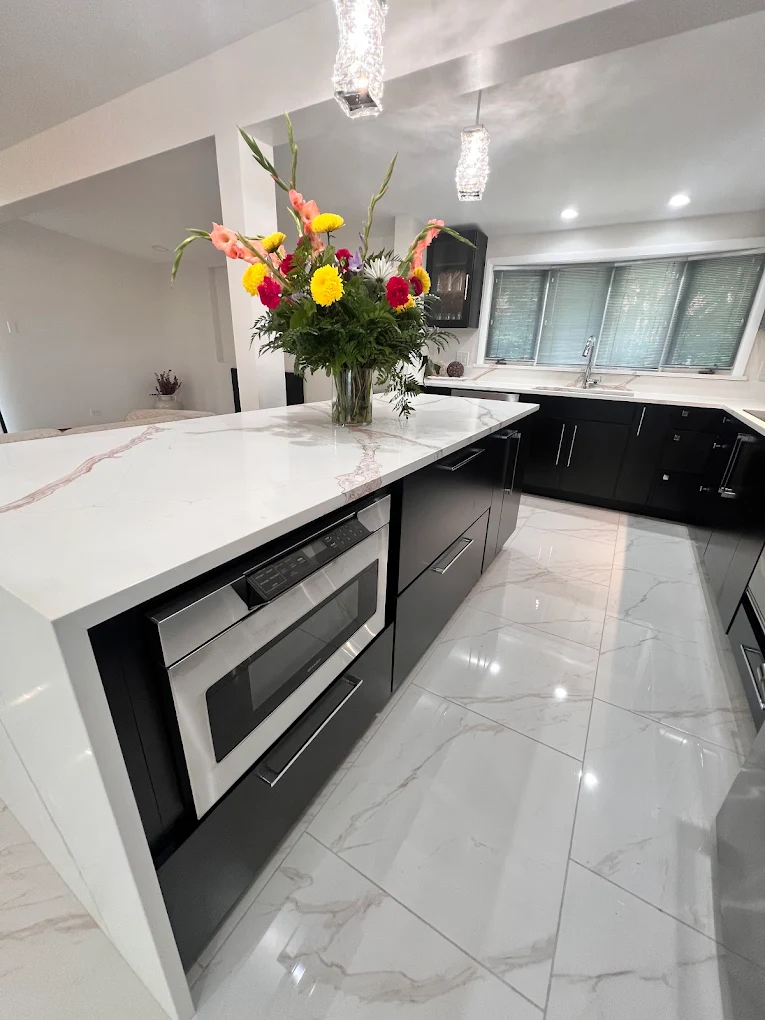 Dark Cabinetry & Marble-Look Kitchen after photo: Island seating with microwave drawer