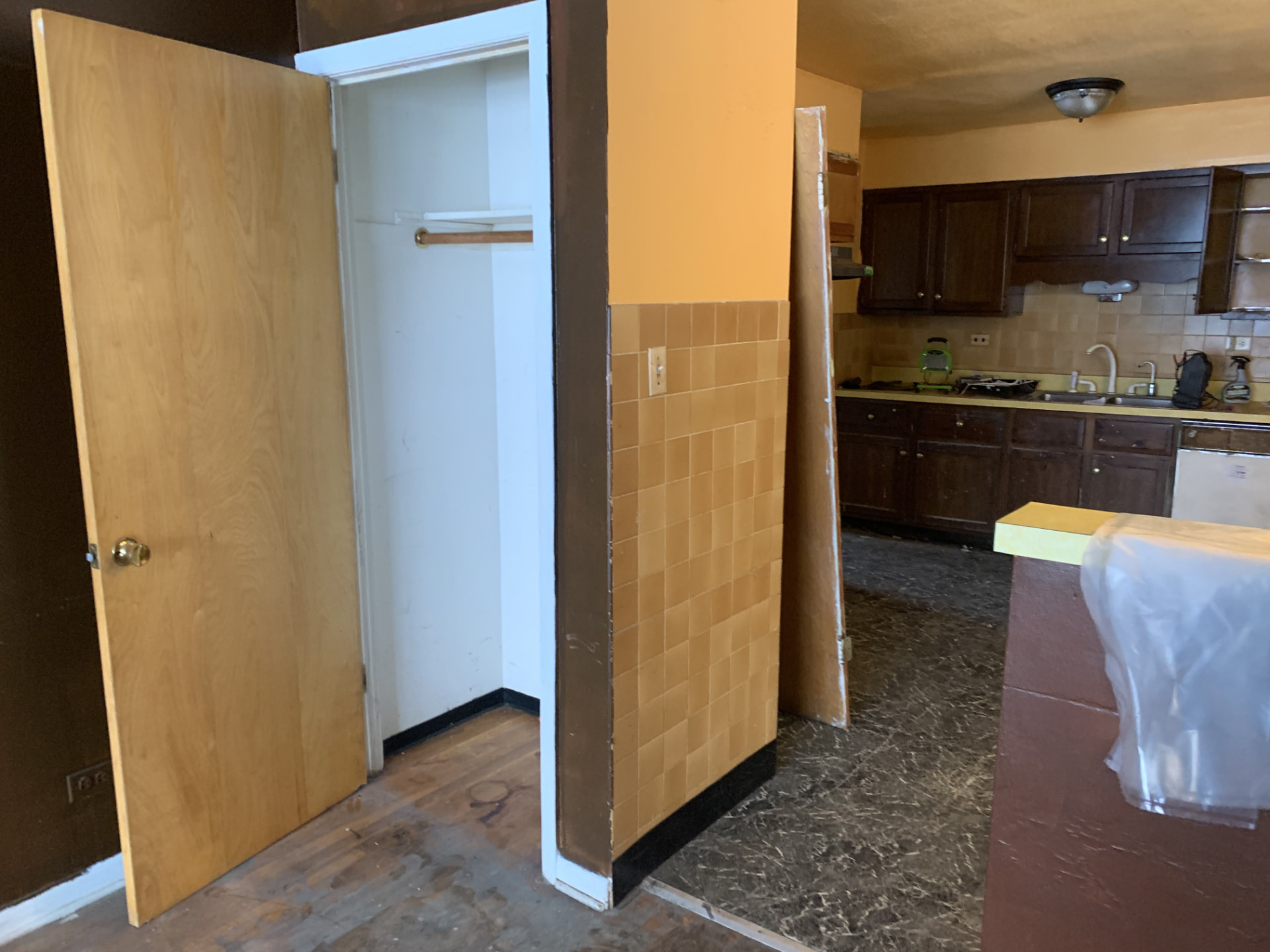 Dark Shaker Kitchen & Granite Counters before photo: Kitchen before the remodel — view from the hallway with worn flooring