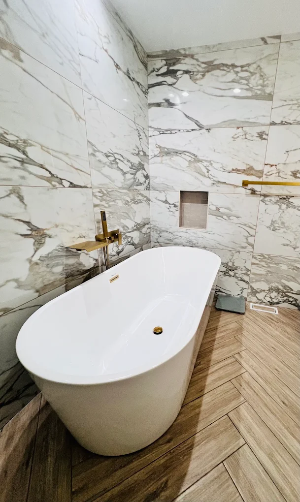 Marble & Gold Primary Bath after photo: Freestanding tub and recessed niche