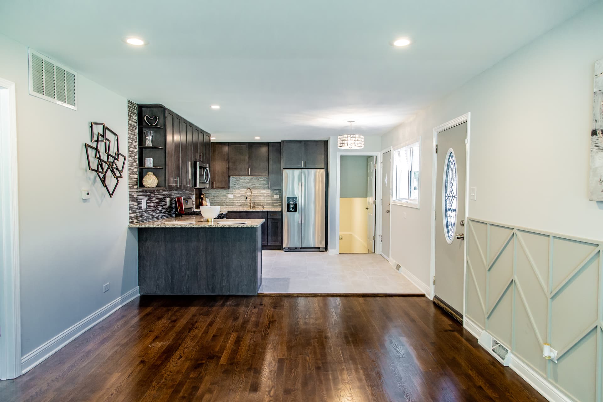 Dark Shaker Kitchen & Granite Counters after photo: Open view from the living room to the kitchen peninsula