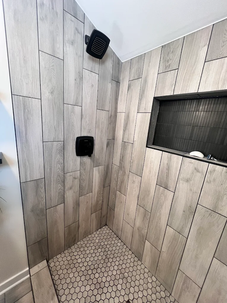 Wood-Look Tile & Matte Black after photo: Matte black shower head and valve with wide niche