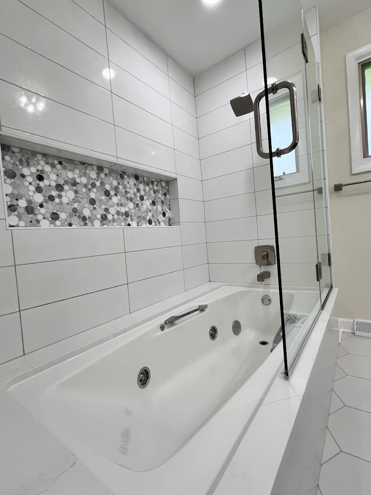 Jetted Tub & Walnut Vanity after photo: Jetted tub with long pebble mosaic niche