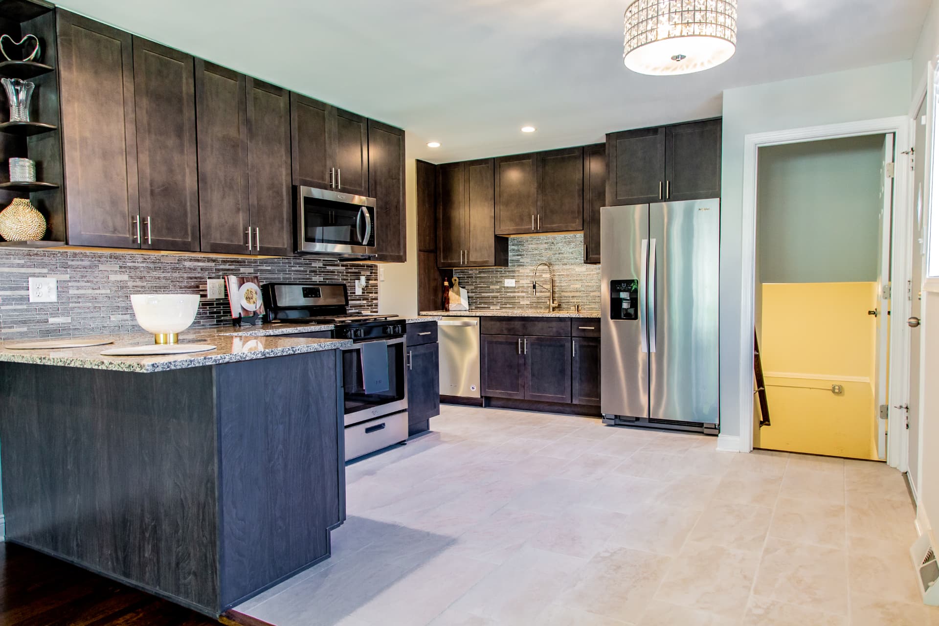 Dark Shaker Kitchen & Granite Counters after photo: Full kitchen with dark shaker cabinets, granite counters, and mosaic backsplash