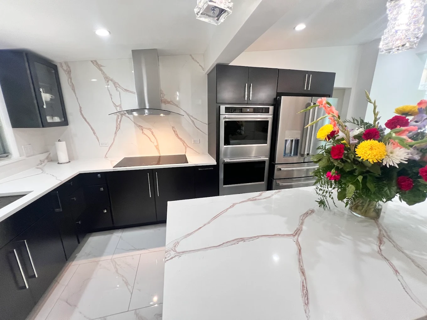 Dark Cabinetry & Marble-Look Kitchen after photo: Kitchen island and appliance wall