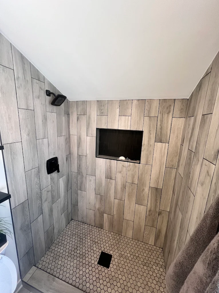 Wood-Look Tile & Matte Black after photo: Hexagon mosaic shower floor and matte black fixtures