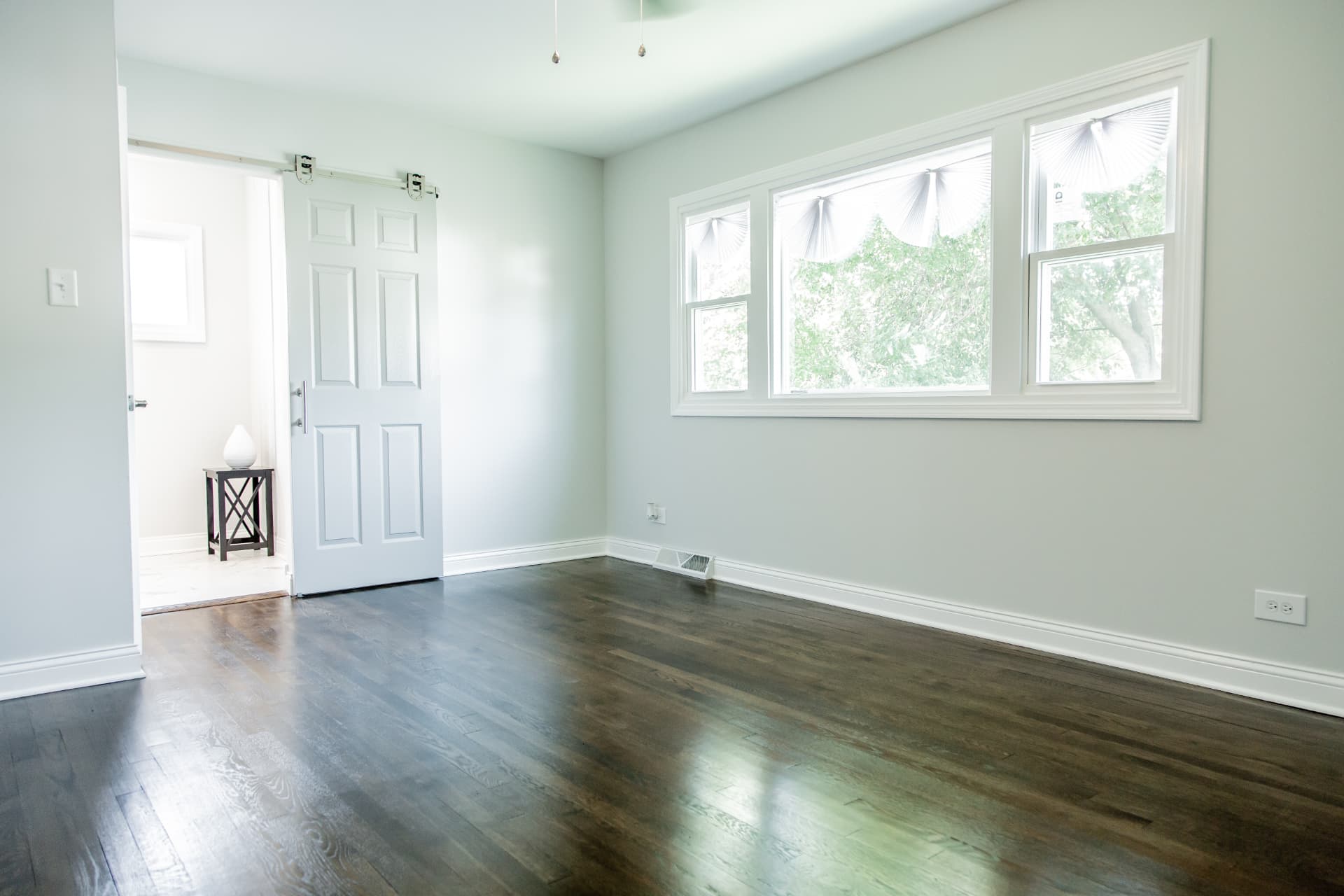 Wood after photo: Finished bedroom with dark wood floors and white trim