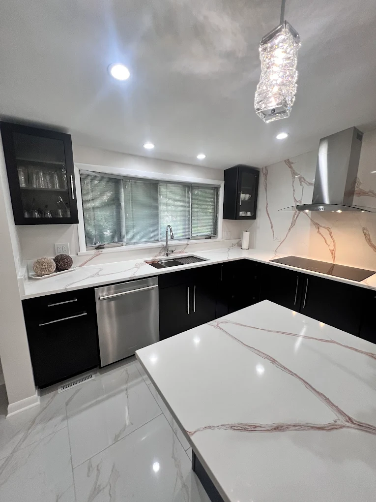 Dark Cabinetry & Marble-Look Kitchen after photo: Sink wall with dishwasher and window