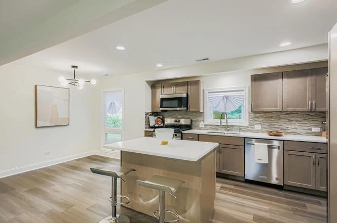 Open Kitchen & Living Room after photo: Open kitchen with quartz island and glass mosaic backsplash