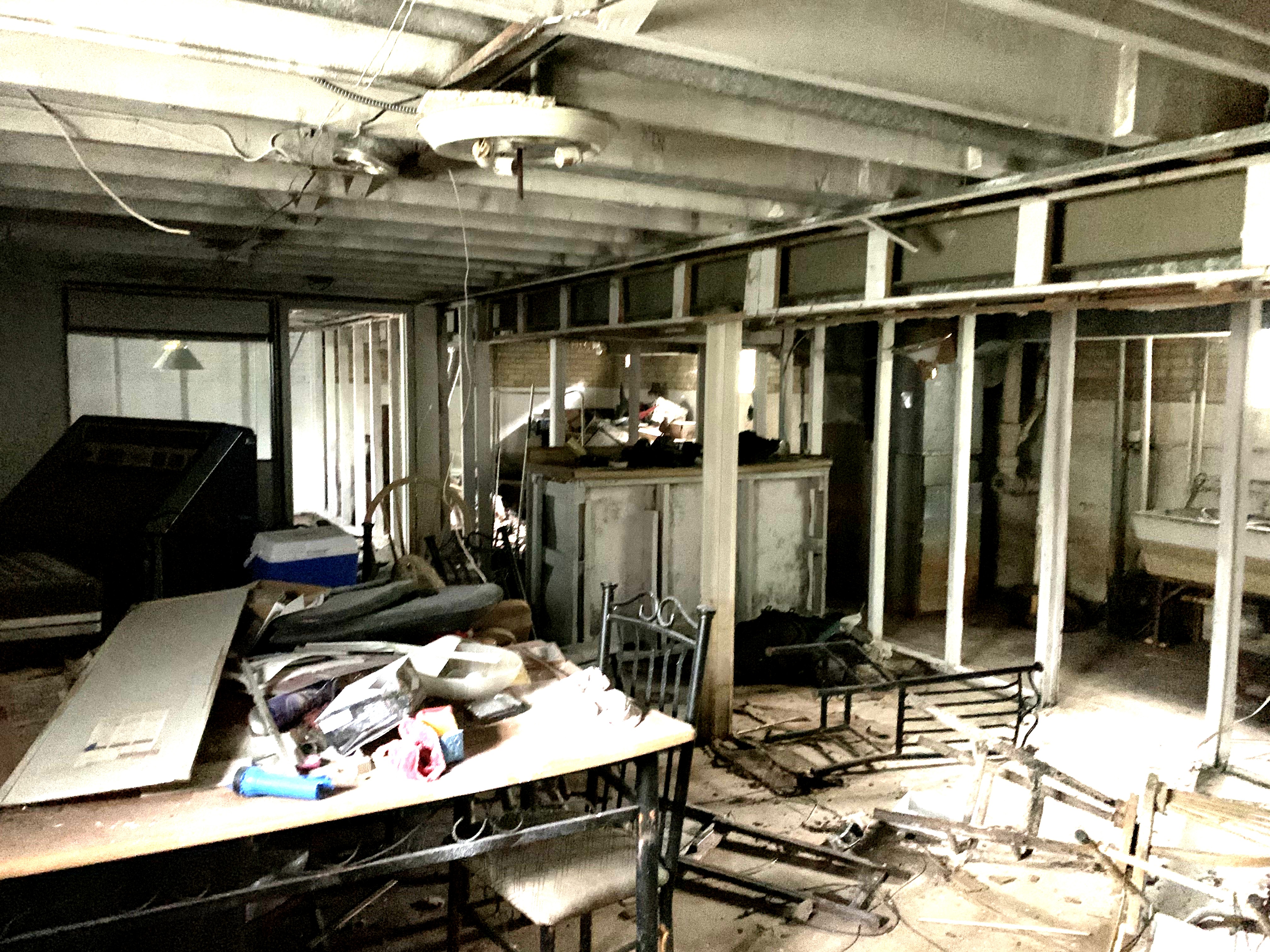 Sawyer before photo: Basement during demolition, with framed walls and an exposed ceiling