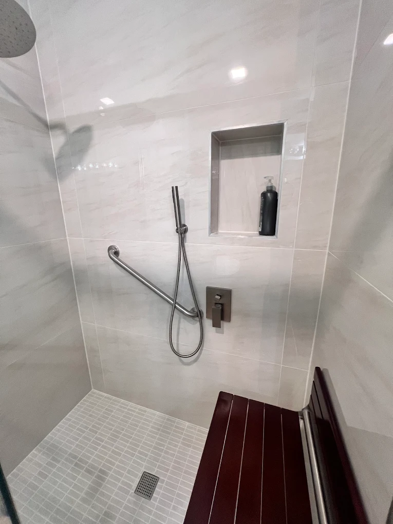 Accessible Walk-In Shower after photo: Grab bar, hand shower, and recessed niche