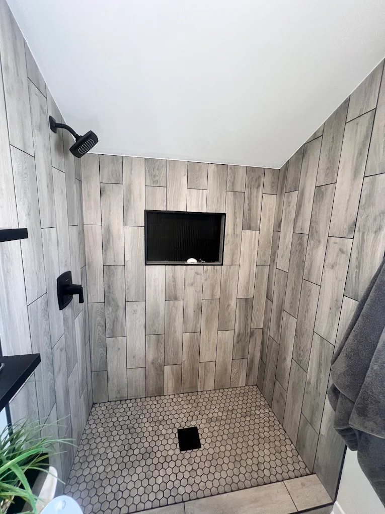 Wood-Look Tile & Matte Black after photo: Wood-look tile shower with black niche