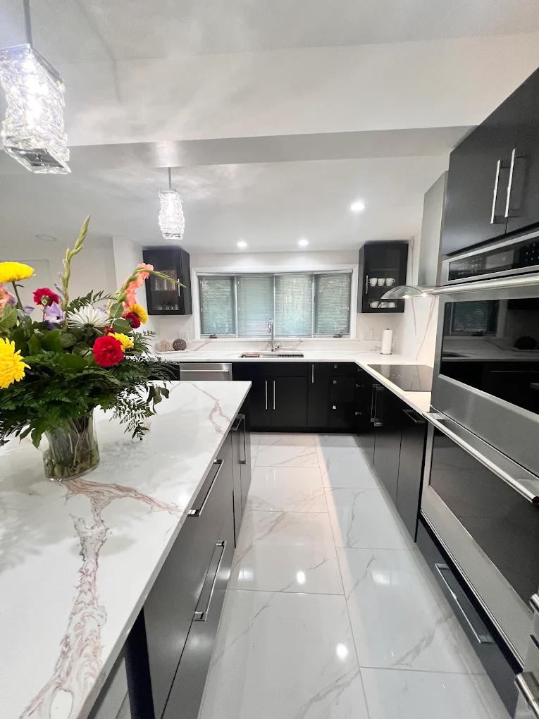Dark Cabinetry & Marble-Look Kitchen after photo: Island with microwave drawer and window over the sink